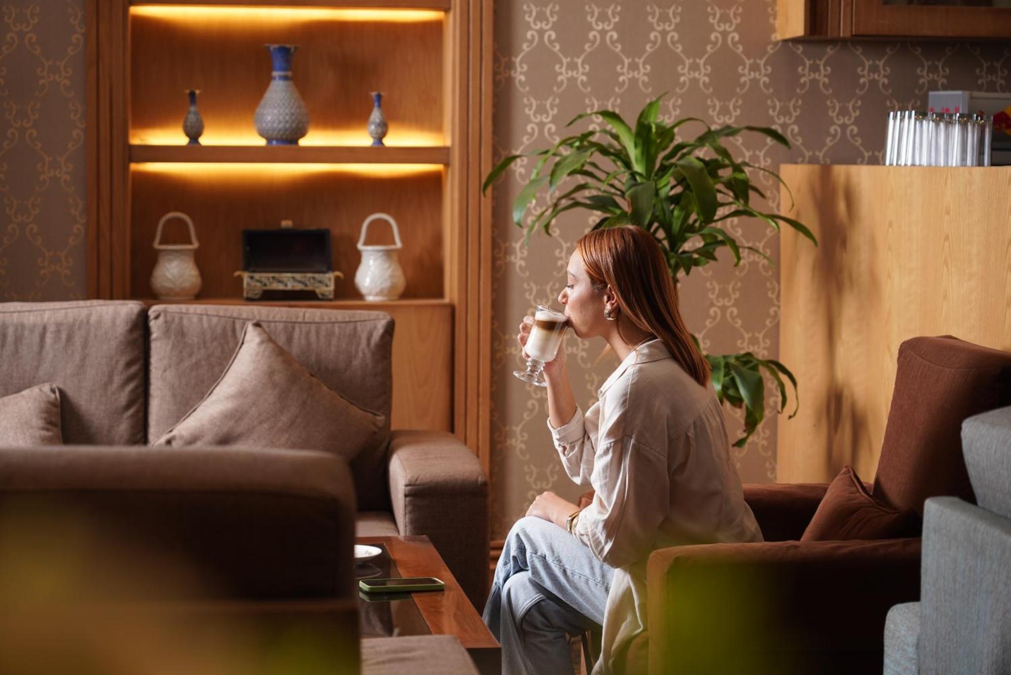 Thousand Nights Hotel Amman Zewnętrze zdjęcie A woman drinking coffee